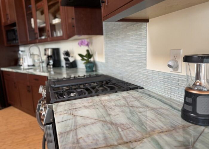 Screenshot Modern kitchen with stove and marble countertop.